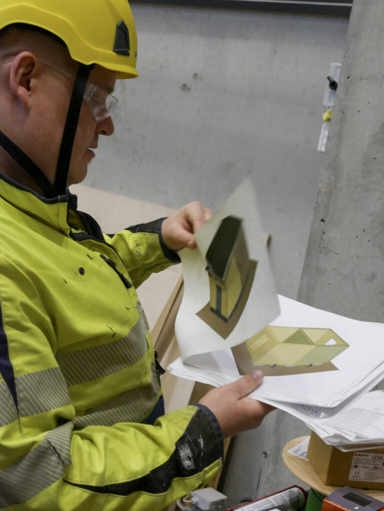 Opiskelija selaa testitalon rakennuspiirustuksia.