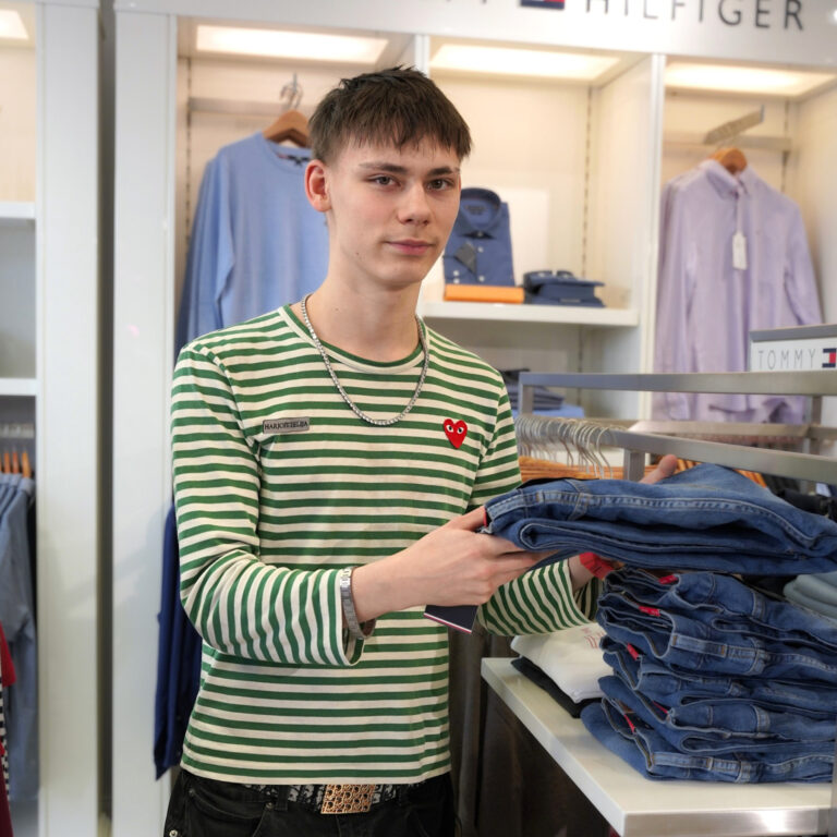 Artikkelissa haastateltu opiskelija asettaa farkkuja esille myymälään